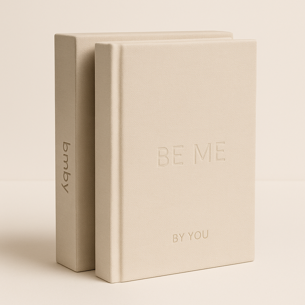 Two beige books with 'BE ME BY YOU' text on a light beige background