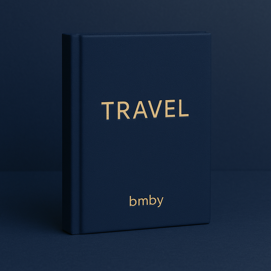 Navy blue book with 'TRAVEL' and 'bmby' in gold on a dark blue background
